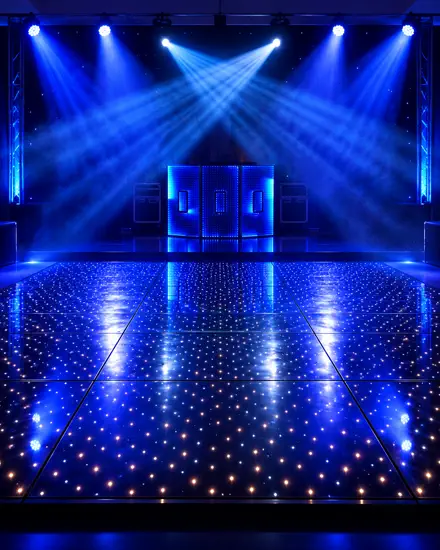 Pista de dança de LED estrelada em azul, com a cabine de DJ acesa e treliça de luz ao fundo