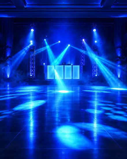 Palco de DJ em azul, com torres de treliça e a pista ainda vazia